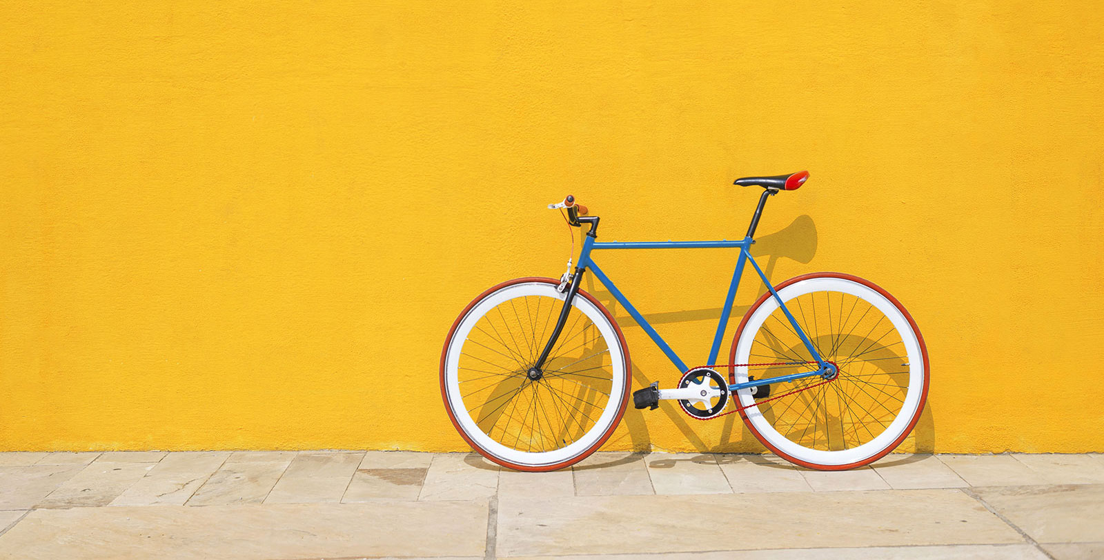 A bicycle leaning against a brick wall.